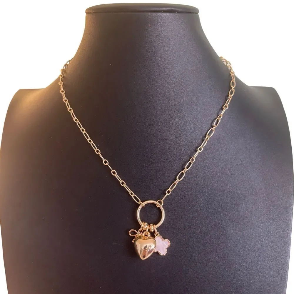 Gold Tone Multi-Charm Necklace w/ Puffy Heart, White Clocer & Gold Bow.